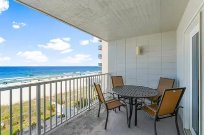 a balcony with a table and chairs and the ocean at Mariner West #403 in Panama City Beach