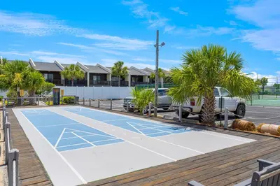 a tennis court in a parking lot with palm trees at Mariner West #403 in Panama City Beach