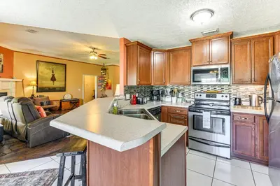 a kitchen with wooden cabinets and a counter top at 2 Mi to Beach and Boating Family Home in Lynn Haven in Lynn Haven