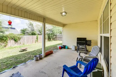 a patio with two blue chairs and a grill at 2 Mi to Beach and Boating Family Home in Lynn Haven in Lynn Haven