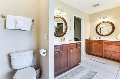 a bathroom with a toilet and a sink and a mirror at 2 Mi to Beach and Boating Family Home in Lynn Haven in Lynn Haven