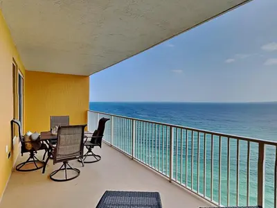 a balcony with a table and chairs and the ocean at Treasure Island #1707 in Panama City Beach