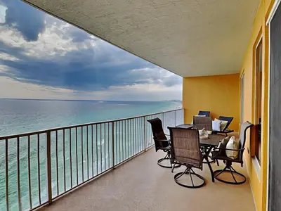 a balcony with a table and chairs and the ocean at Treasure Island #1707 in Panama City Beach
