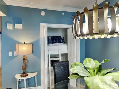 a dining room with blue walls and a chandelier at Treasure Island #1707 in Panama City Beach