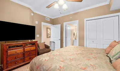 a bedroom with a bed and a flat screen tv at Palazzo 1405 by Emerald Coast Retreats in Panama City Beach