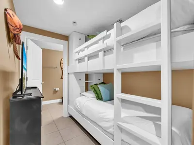 a white bunk bed in a room with a television at Palazzo 1405 by Emerald Coast Retreats in Panama City Beach
