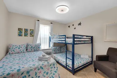 a bedroom with a bunk bed and a couch at Pier Atlas (3/2) in Panama City Beach