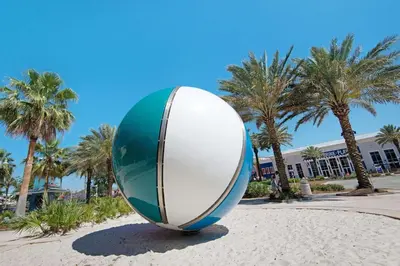 a large surfboard sculpture in a park with palm trees at Pier Atlas (3/2) in Panama City Beach