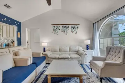 a living room with two couches and a table at Pier Atlas (3/2) in Panama City Beach