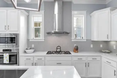 a white kitchen with white cabinets and a stove at Sunny Side Up in Inlet Beach