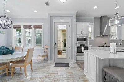 a white kitchen with a table and a dining room at Sunny Side Up in Inlet Beach