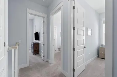 a white hallway with a door and a television at Sunny Side Up in Inlet Beach