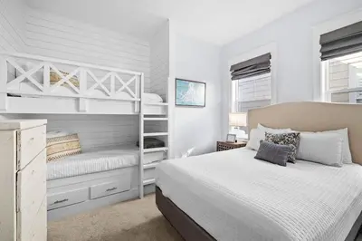 a white bedroom with a bed and bunk beds at Sunny Side Up in Inlet Beach