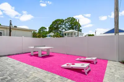a pink rug with a table and a bench on it at Pink Prerogative Beach Bungalow with Private Pool in Panama City Beach