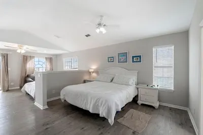 a white bedroom with a bed and a dresser and window at Tranquil Beach & Hot Tub & Pool Getaway in Panama City Beach
