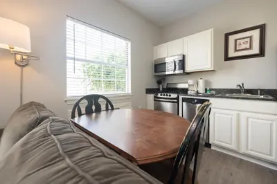 a kitchen with a wooden table and a couch at Tranquil Beach & Hot Tub & Pool Getaway in Panama City Beach