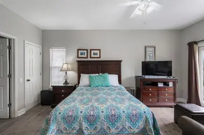 a bedroom with a bed and a flat screen tv at Tranquil Beach & Hot Tub & Pool Getaway in Panama City Beach