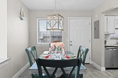 a dining room with a table and chairs at The Pink Flamingo by Book That Condo in Panama City Beach