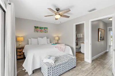 a bedroom with a bed and a ceiling fan at The Pink Flamingo by Book That Condo in Panama City Beach