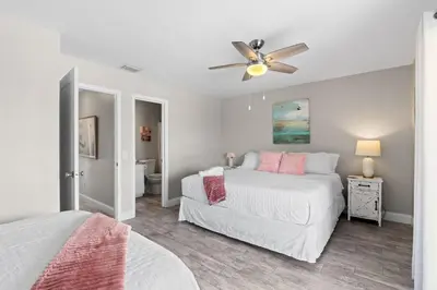 a bedroom with two beds and a ceiling fan at The Pink Flamingo by Book That Condo in Panama City Beach