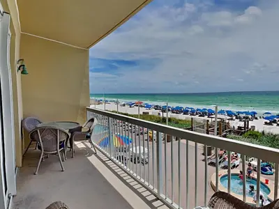 a balcony with a table and chairs and the beach at Seychelles #206 in Panama City Beach