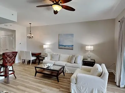 a living room with white furniture and a ceiling fan at Seychelles #206 in Panama City Beach
