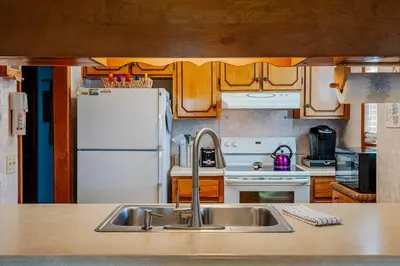 a kitchen with a sink and a white refrigerator at Horizon Breeze - Family Escape in Panama City Beach