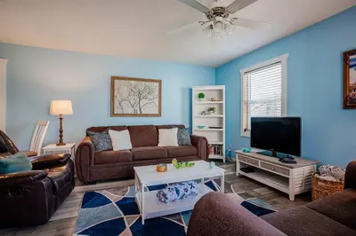 a living room with a couch and a tv at Horizon Breeze - Family Escape in Panama City Beach