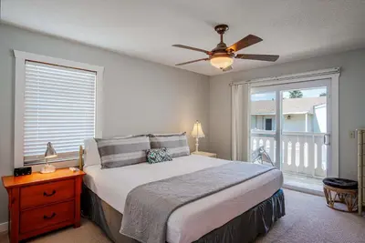 a bedroom with a bed with a ceiling fan and a window at Horizon Breeze - Family Escape in Panama City Beach