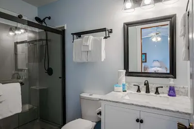 a bathroom with a toilet and a sink and a mirror at Horizon Breeze - Family Escape in Panama City Beach