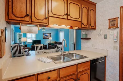 a kitchen with a sink and a living room at Horizon Breeze - Family Escape in Panama City Beach