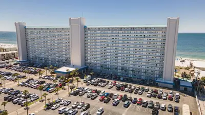 a large building with cars parked in a parking lot at Mariners Retreat - High Rise Beach Living in PCB in Panama City Beach