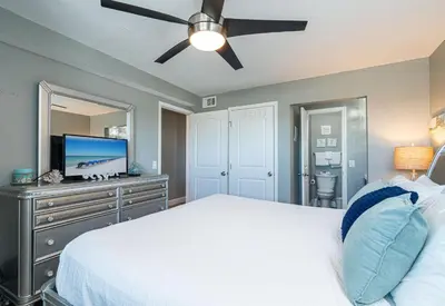 a bedroom with a bed and a ceiling fan at Mariners Retreat - High Rise Beach Living in PCB in Panama City Beach