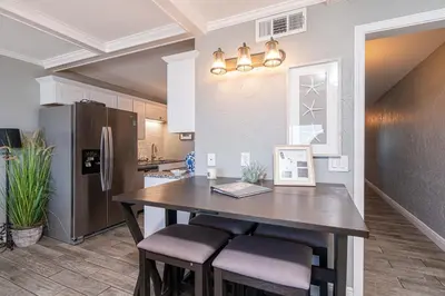 a kitchen with a large wooden table and chairs at Mariners Retreat - High Rise Beach Living in PCB in Panama City Beach