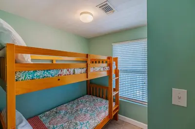 a bedroom with two bunk beds and a window at Ocean View Escape - Beach Resort in Panama City Beach