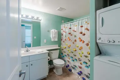 a bathroom with a toilet and a shower curtain at Ocean View Escape - Beach Resort in Panama City Beach