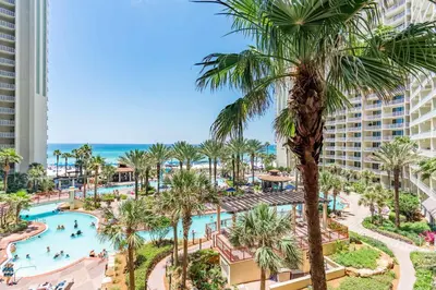 an aerial view of the pool at the resort with palm trees at Ocean View Escape - Beach Resort in Panama City Beach