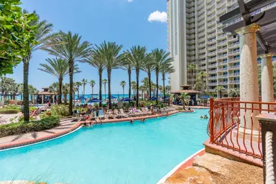 a swimming pool at a resort with palm trees at Ocean View Escape - Beach Resort in Panama City Beach