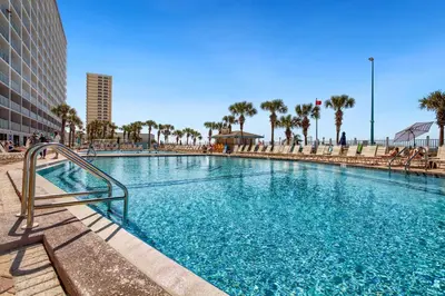 a large swimming pool in a city with palm trees at Ocean View Retreat - Beachfront Bliss in Panama City Beach