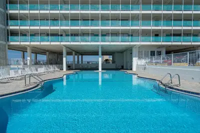 a large swimming pool in front of a building at Coral Cove Beachfront Condo for 3 with Onsite Pool in Panama City Beach