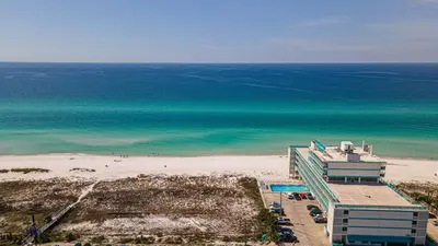 a view of a beach with a building and the ocean at Coral Cove Beachfront Condo for 3 with Onsite Pool in Panama City Beach