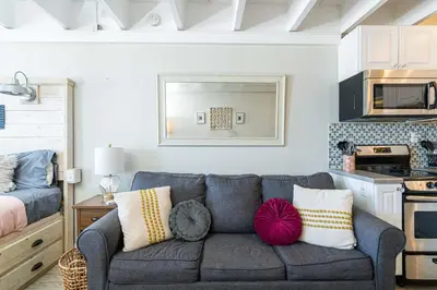a living room with a couch and a kitchen at Coral Cove Beachfront Condo for 3 with Onsite Pool in Panama City Beach