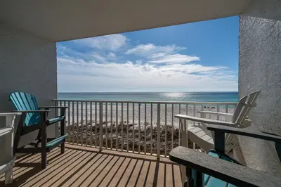 a balcony with chairs and a view of the ocean at Edgewater Oasis Gorgeous Resort Condo on Beach in Panama City Beach