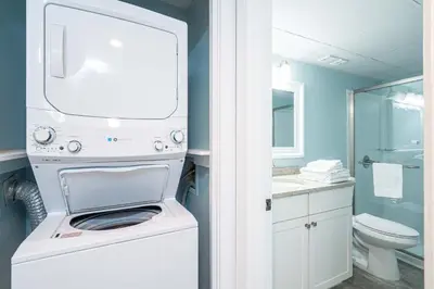 a white washer and dryer in a bathroom at Edgewater Oasis Gorgeous Resort Condo on Beach in Panama City Beach