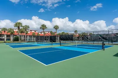 a tennis court with two tennis courts at Edgewater Oasis Gorgeous Resort Condo on Beach in Panama City Beach