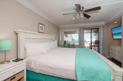 a bedroom with a bed and a ceiling fan at Sea Forever - Cozy Oceanfront Condo in Panama City Beach