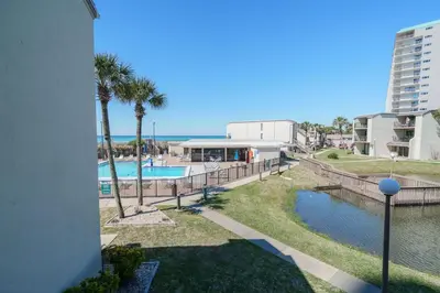 a view of the pool at a resort with palm trees at Sea Forever - Cozy Oceanfront Condo in Panama City Beach