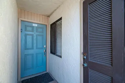 a blue door on the side of a house at Sea Forever - Cozy Oceanfront Condo in Panama City Beach