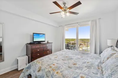 a bedroom with a bed and a ceiling fan at Seaside Harmony - Stunning High-Rise Resort Condo in Panama City Beach