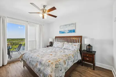 a bedroom with a bed and a ceiling fan at Seaside Harmony - Stunning High-Rise Resort Condo in Panama City Beach